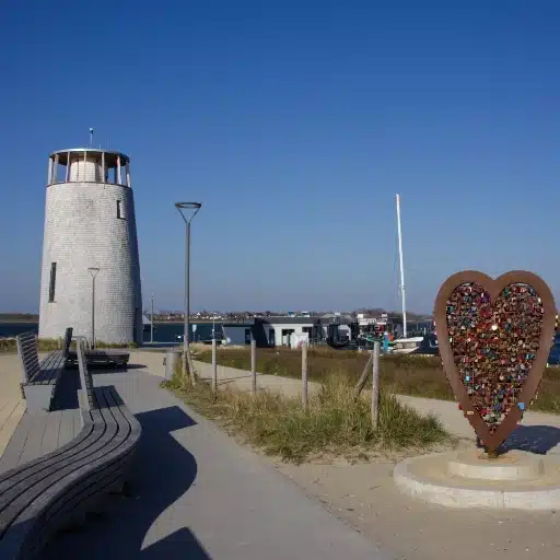 Sehenwürdigkeit Aussichtsturm Utkieker in Burgtiefe auf Fehmarn auf der linken Seite und rechts ein Metallherz