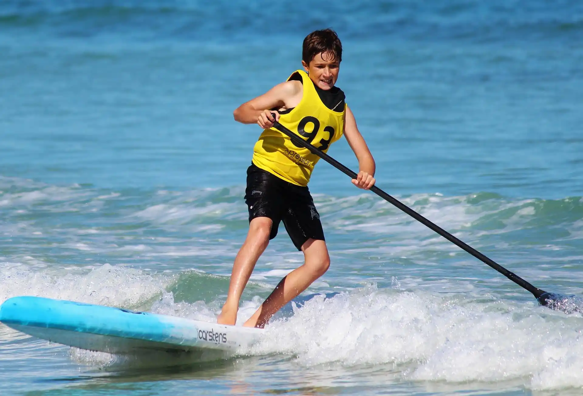 Junge auf einem SUP Board mit SUP Paddel auf der Ostsee bei Fehmarn