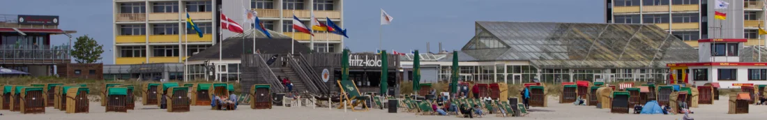 Blick auf das Vitarium am Südstrand auf Fehmarn, das etwas hinter einer Strandbar verborgen ist.