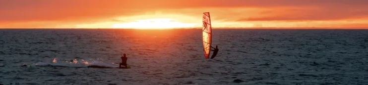 Windsurfer und Kitesurfer nebeneinander auf der Ostsee bei Fehmarn