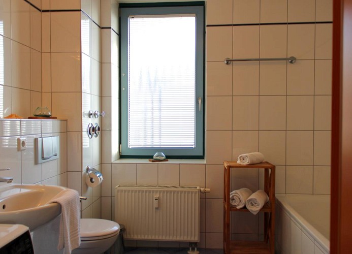 Geräumiges Badezimmer mit WC, Waschbecken, Dusche und Badewanne in der Inselblume 55 auf Fehmarn