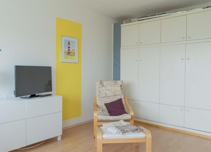 Sessel vor dem Schrankbett in der Ferienwohnung in Burgtiefe
