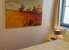 Schlafzimmer mit großem Bild in der Ferienwohnung direkt am Meer
