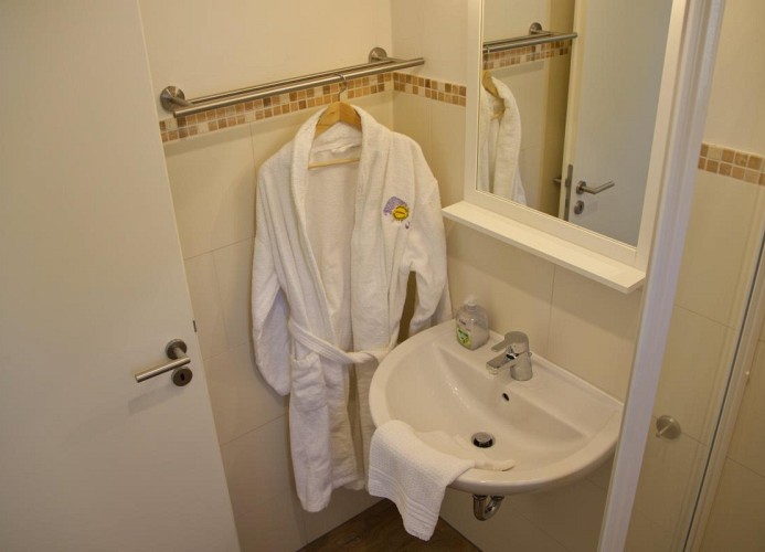 Bademantel und Waschbecken im Badezimmer im Erdgeschoss der Inselblume 28
