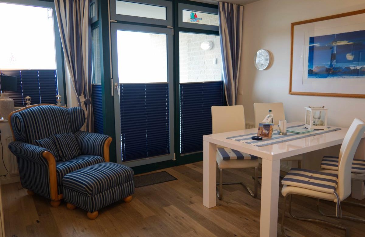 Esstisch und Sessel im Wohnzimmer der Ferienwohnung am Südstrand