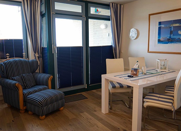 Esstisch und Sessel im Wohnzimmer der Ferienwohnung am Südstrand