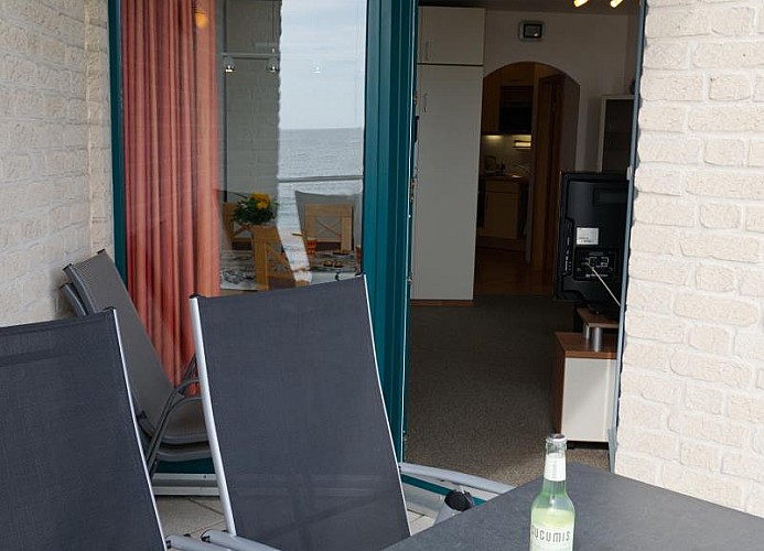 Blick vom Balkon ins Wohnzimmer der Ferienwohnung Inselblume 03 auf Fehmarn