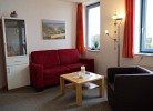 Wohnzimmer mit Couch und Sessel in der Ferienwohnung Inselblume 03 auf Fehmarn