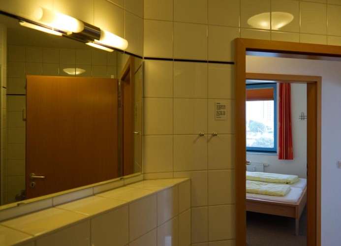 Blick aus dem Bad ins Schlafzimmer der Ferienwohnung Inselblume 03 auf Fehmarn