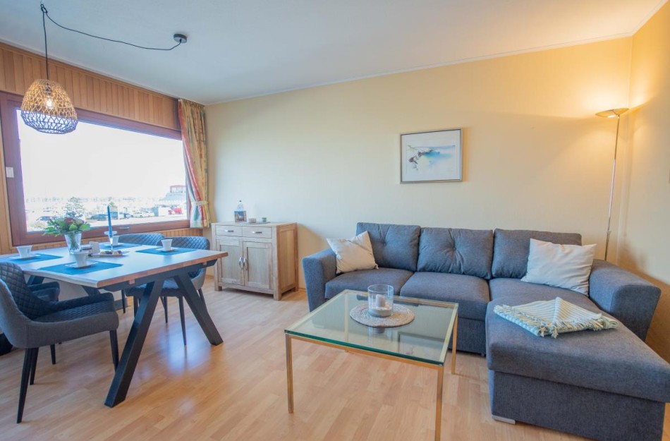Wohnzimmer der Inselblume 11 mit Couch und Blick auf den Yachthafen 