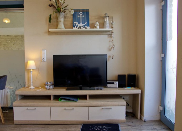 TV im Wohnzimmer der Ferienwohnung Inselblume 48 mit Hund auf Fehmarn