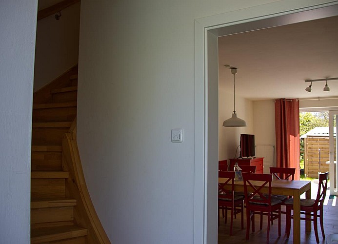 Blick auf die Treppe in die 1. Etage und ins Wohnzimmer der Inselblume 28 vom Flur aus