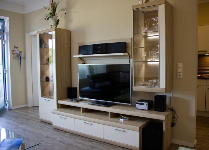 TV und Regale im Wohnzimmer der Ferienwohnung am Südstrand, in der Strandburg