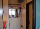 Flur mit Küchenzeile und Tür zum Badezimmer in der Inselblume 83