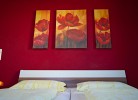Doppelbett mit Bildern von Mohn über dem Bett in dem Ferienhaus auf Fehmarn