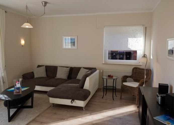 Anderer Blick auf die Couch und das Wohnzimmer der Fewo auf Fehmarn