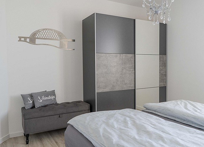 Schrank mit Sitzgelegenheit im Schlafzimmer der Ferienwohnung in Burg