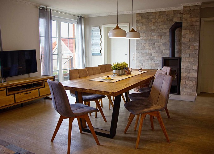 Esstisch mit TV und Zugang zu den Schlafzimmern in der Ferienwohnung für 7 Personen