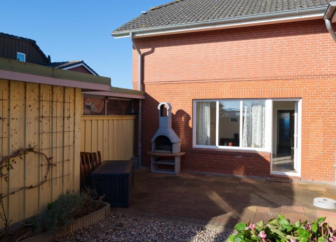 Blick vom Garten in Richtung Ferienwohnung mit Hund auf Fehmarn