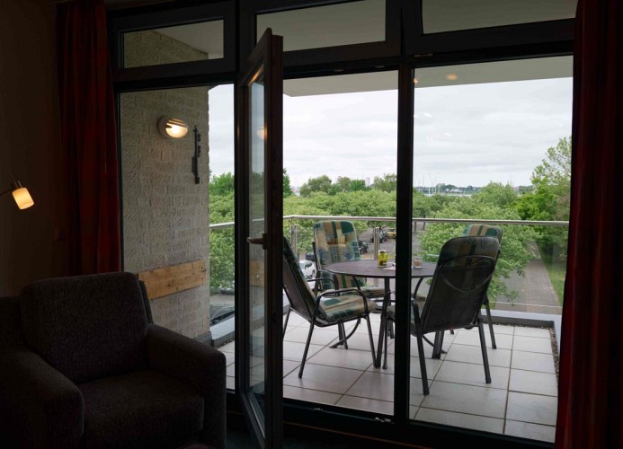 Blick auf den Balkon aus dem Wohnzimmer der Ferienwohnung für 4 Personen auf Fehmarn