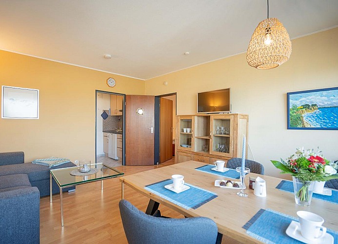 Das große Wohnzimmer mit Essbereich und TV in der Ferienwohnung Inselblume 11