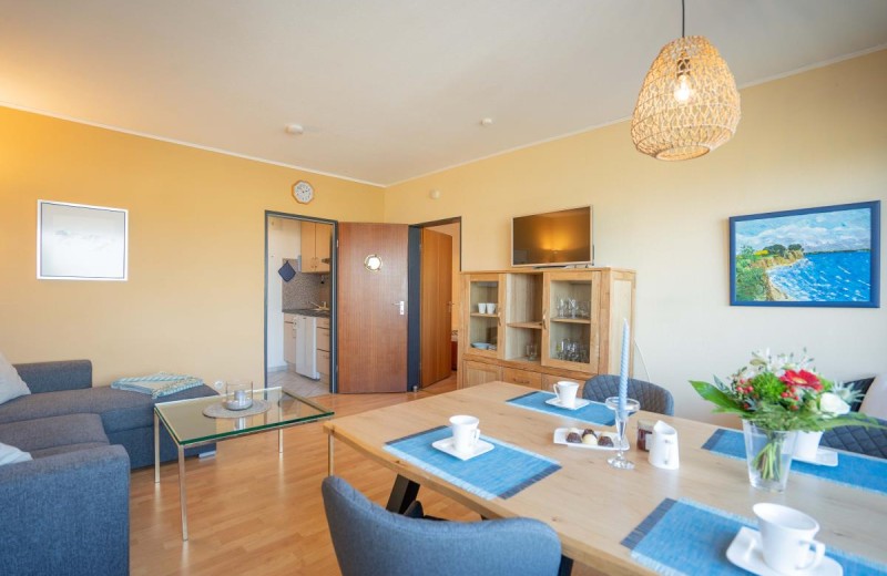 Das große Wohnzimmer mit Essbereich und TV in der Ferienwohnung Inselblume 11
