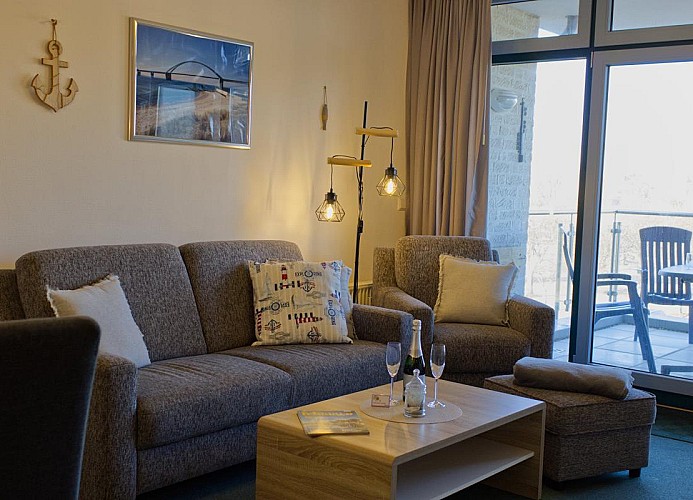 Couch und Sessel in der Ferienwohnung mit Balkon direkt am Südstrand