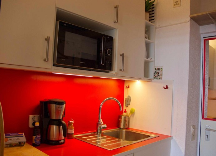 Küche mit Küchenschränken und Waschbecken in der Ferienunterkunft Inselblume 83 auf Fehmarn