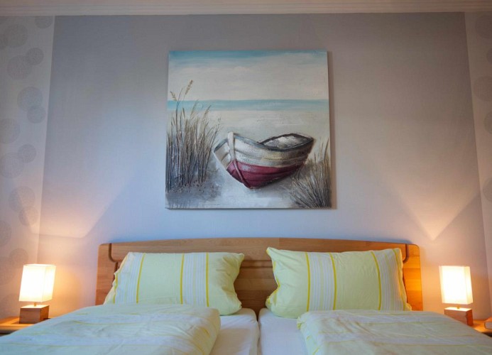 Doppelbett mit Bild vom Schiff in der Ferienwohnung Inselblume 15 mit Garten