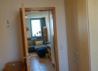 Blick aus dem Schlafzimmer in das Wohnzimmer der Ferienwohnung mit Hund