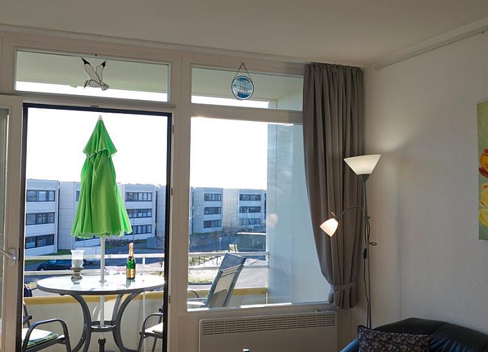 Wohnzimmer und Balkon der Ferienwohnung auf Fehmarn