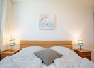 Doppelbett mit Nachttischen im Schlafzimmer der Ferienwohnung Inselblume 56