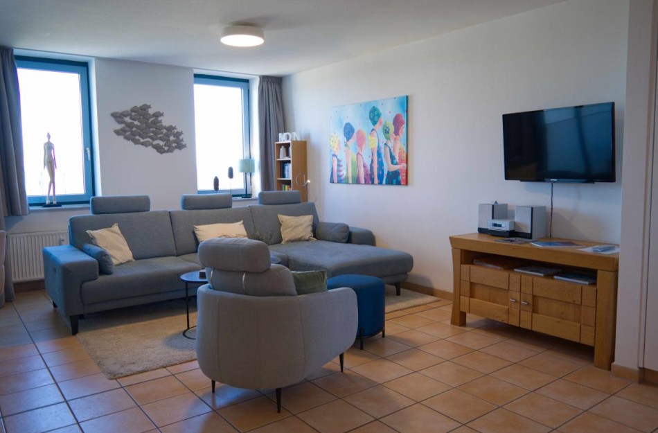 Wohnzimmer mit Couch und Sessel in der Ferienwohnung in der Strandburg auf Fehmarn