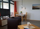 Blick auf den TV und Esstisch von der Couch der Ferienwohnung Inselblume 03 auf Fehmarn