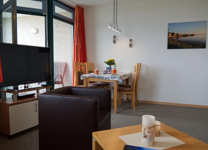 Blick auf den TV und Esstisch von der Couch der Ferienwohnung Inselblume 03 auf Fehmarn