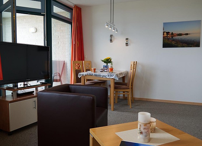 Blick auf den TV und Esstisch von der Couch der Ferienwohnung Inselblume 03 auf Fehmarn