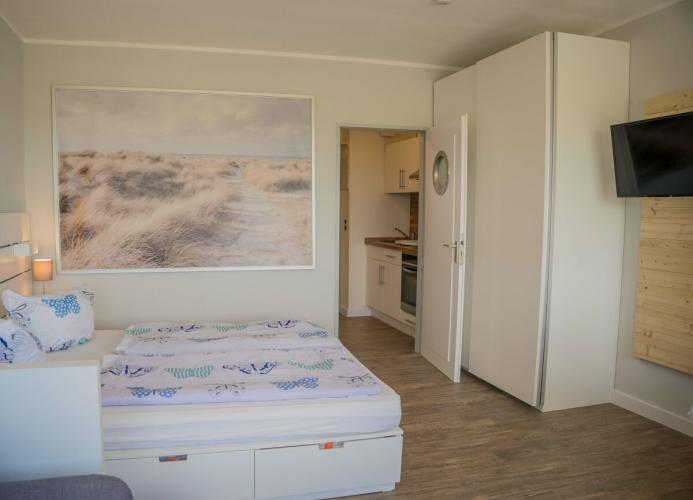 Doppelbett mit Schrank im Wohnzimmer der Fewo direkt am Südstrand von Fehmarn