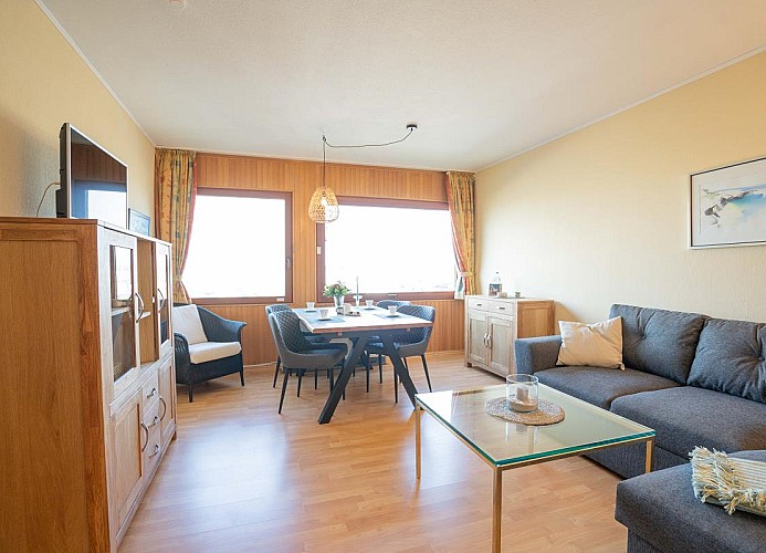 Das Wohnzimmer mit Esstisch, Couch und TV in der Inselblume 11 in Burgtiefe