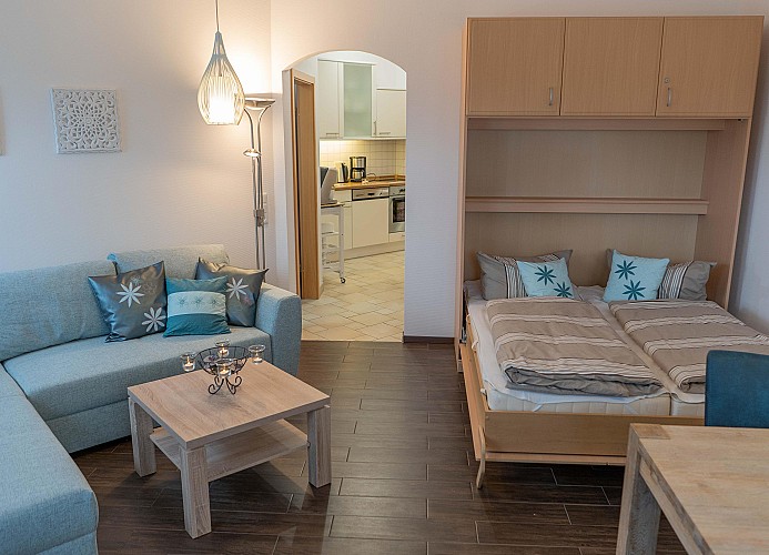 Schrankbett und Couch im Wohnzimmer der Fewo direkt am Südstrand auf Fehmarn