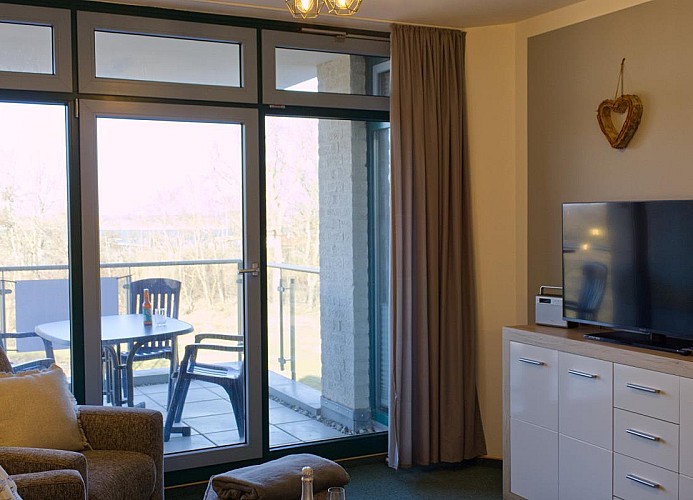 Kommode mit TV im Wohnzimmer der Ferienwohnung am Südstrand in Burgtiefe