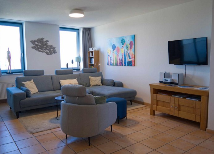 Wohnzimmer mit Couch und Sessel in der Ferienwohnung in der Strandburg auf Fehmarn
