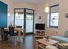 Esstisch mit TV und Couch im Wohnzimmer der Ferienwohnung direkt am Südstrand in Burgtiefe