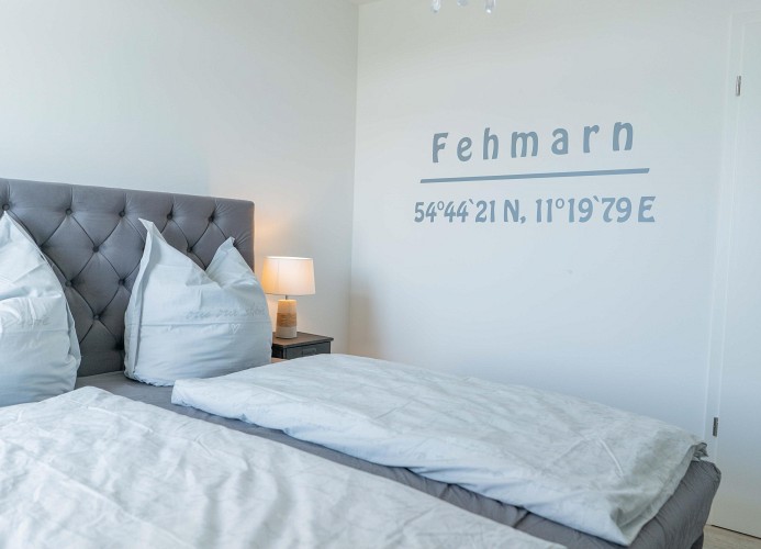 Doppelbett mit Fehmarn Deko an der Wand der Ferienwohnung