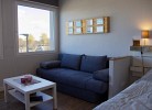 Doppelbett und gemütliche Couch in der Ferienwohnung mit Blick auf den Yachthafen auf Fehmarn