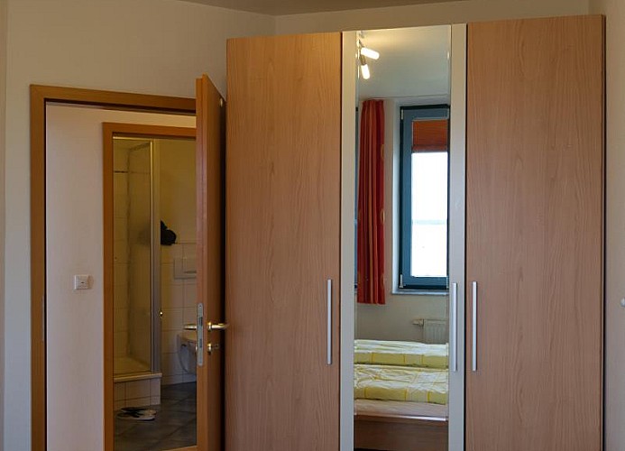 Schrank und die Tür vom Schlafzimmer auf den Flur der Ferienwohnung Inselblume 03 auf Fehmarn