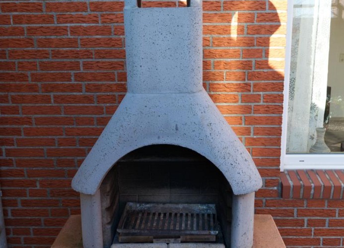Grill auf der Terrasse im Garten der Ferienwohnung mit Hund auf Fehmarn